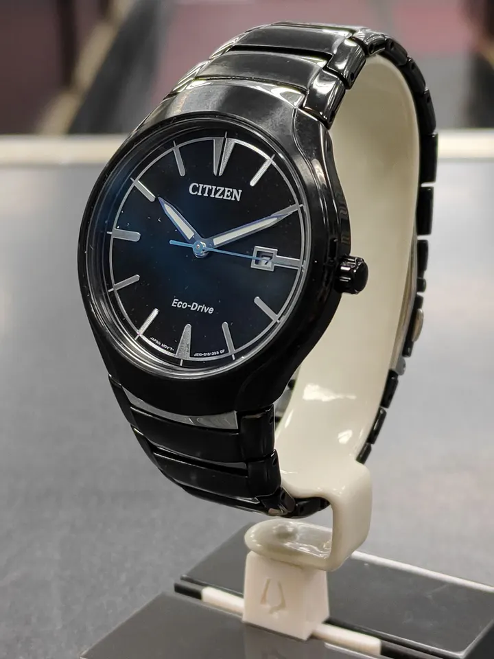 Citizen Eco-Drive black ion-plated stainless steel watch with black dial and date shown from front, side, and ca