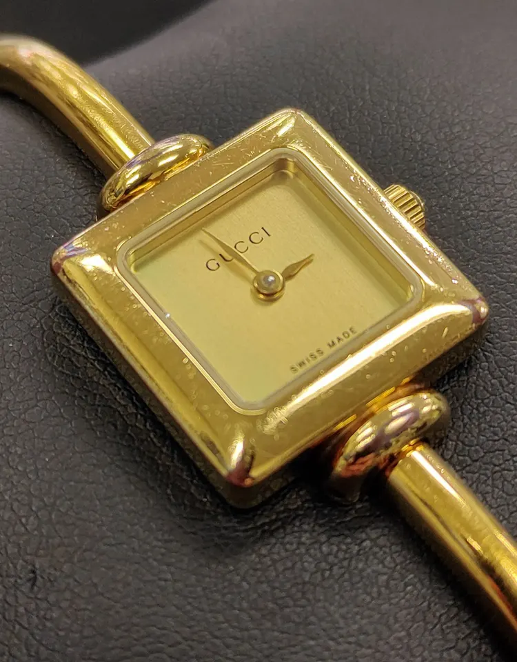 Gucci gold-plated Swiss quartz women's bangle watch with square champagne dial and sapphire crystal