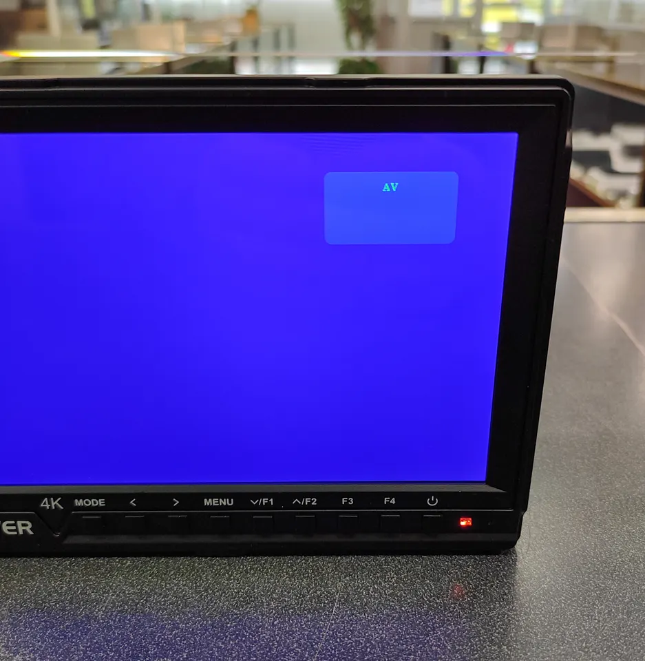 Neewer NW-760 7-inch on-camera field monitor shown powered on, with battery and RavPower dual charger included