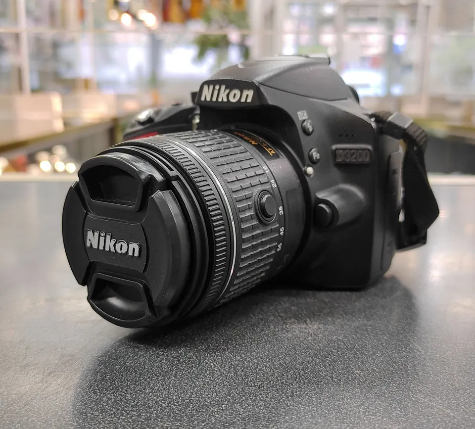 Nikon D3200 DSLR camera body with Nikon battery, charger, 32GB SD card and neck strap