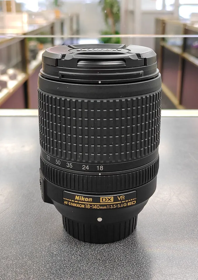 Nikon AF-S DX 18-140mm f/3.5-5.6G ED VR zoom lens with front and rear caps
