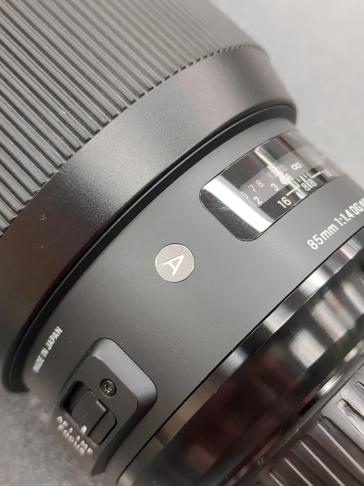Sigma 85mm f/1.4 DG HSM Art Nikon F-mount lens shown from multiple angles with clean front and rear glass, Nikon mount contac