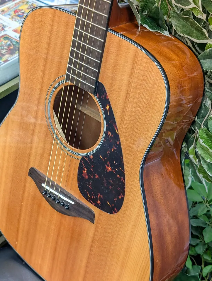 Natural-finish Yamaha FG700S six-string dreadnought acoustic guitar showing its solid spruce top, tortoiseshell-style pickgua