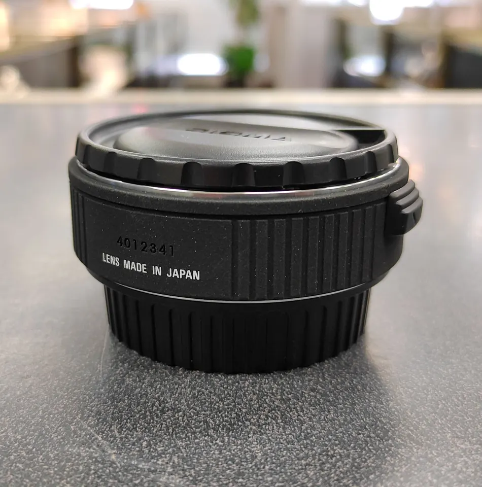 Sigma APO 1.4x EX DG Canon EF teleconverter with front and rear protective caps
