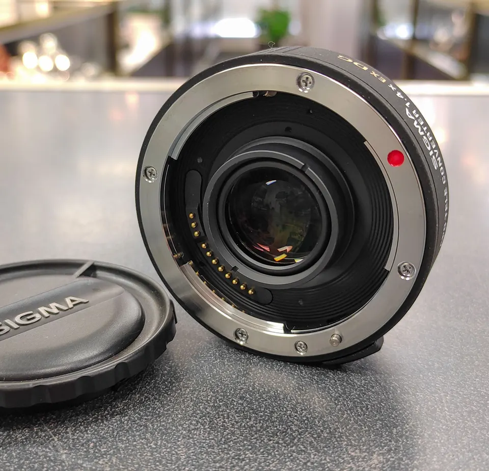 Sigma APO 1.4x EX DG Canon EF teleconverter with front and rear protective caps