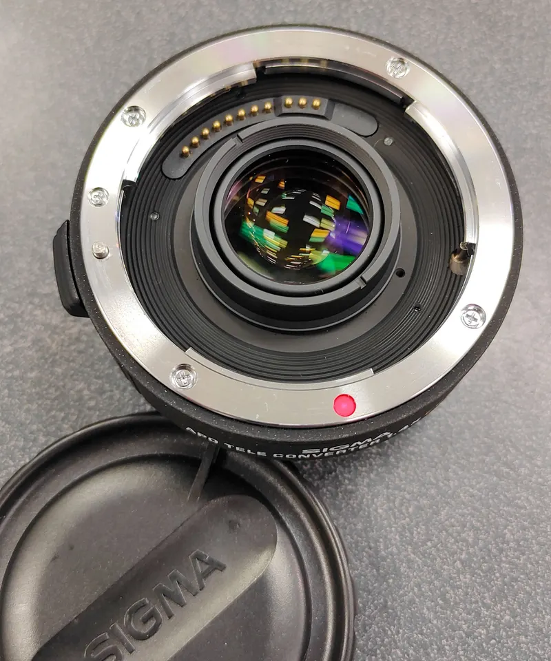 Sigma APO 1.4x EX DG Canon EF teleconverter with front and rear protective caps