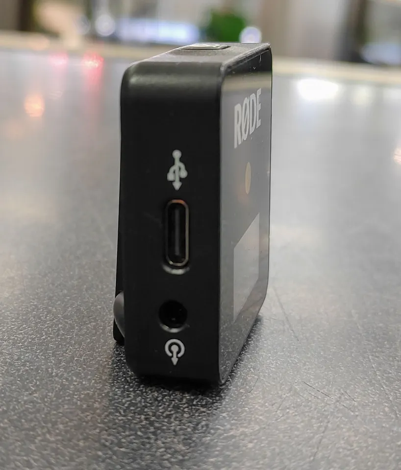 Black RØDE Wireless GO first-generation receiver with built-in clip, display, USB-C charging port, and coiled 3.5mm TRS cable