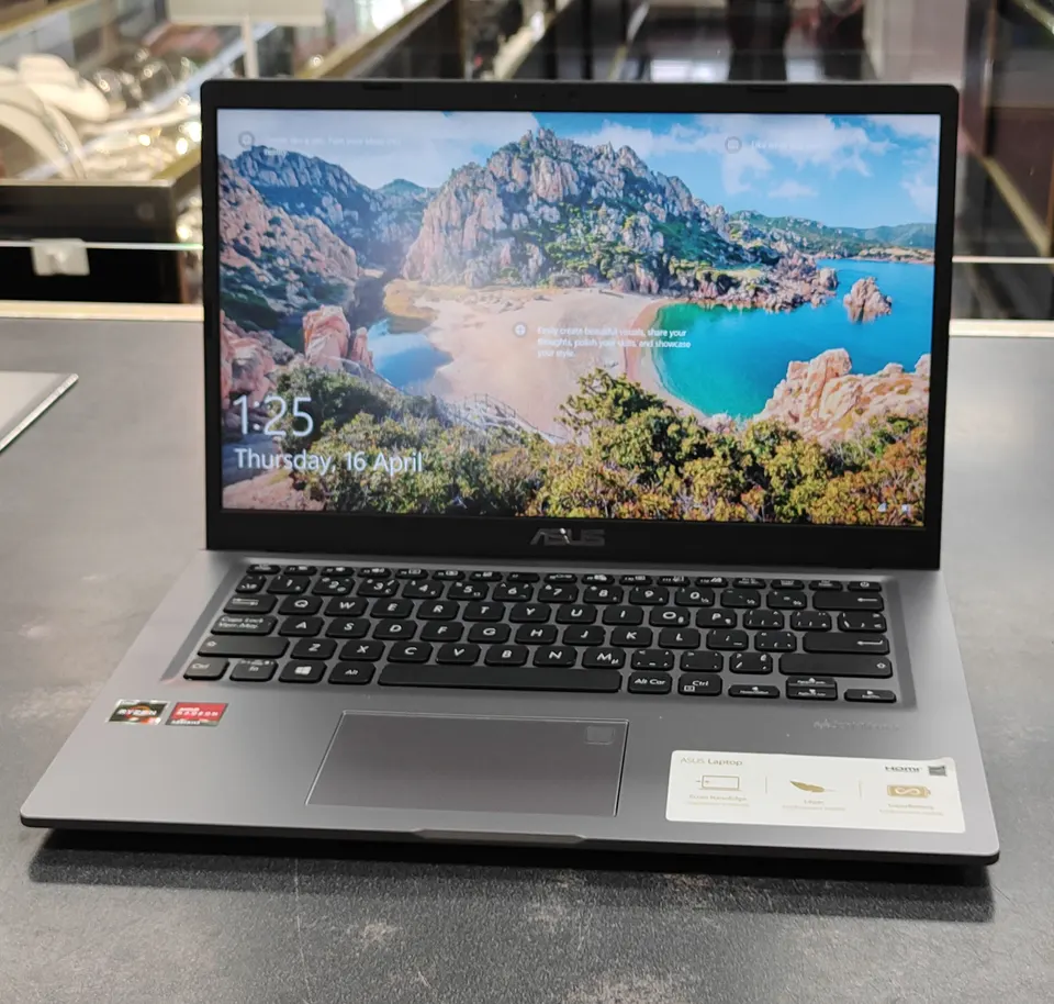 ASUS VivoBook M415DA / X415DAP 14-inch laptop in gray with Ryzen 3 sticker, Windows 10 screen on, and original ASUS charger