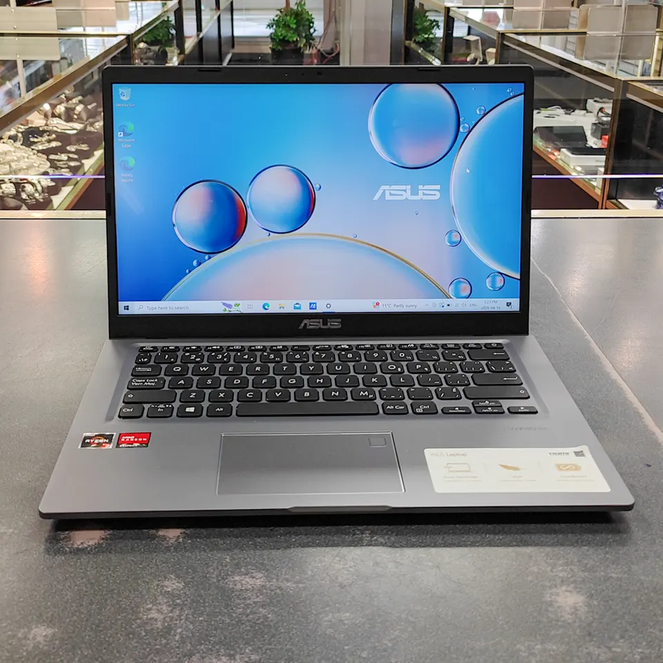ASUS VivoBook M415DA / X415DAP 14-inch laptop in gray with Ryzen 3 sticker, Windows 10 screen on, and original ASUS charger
