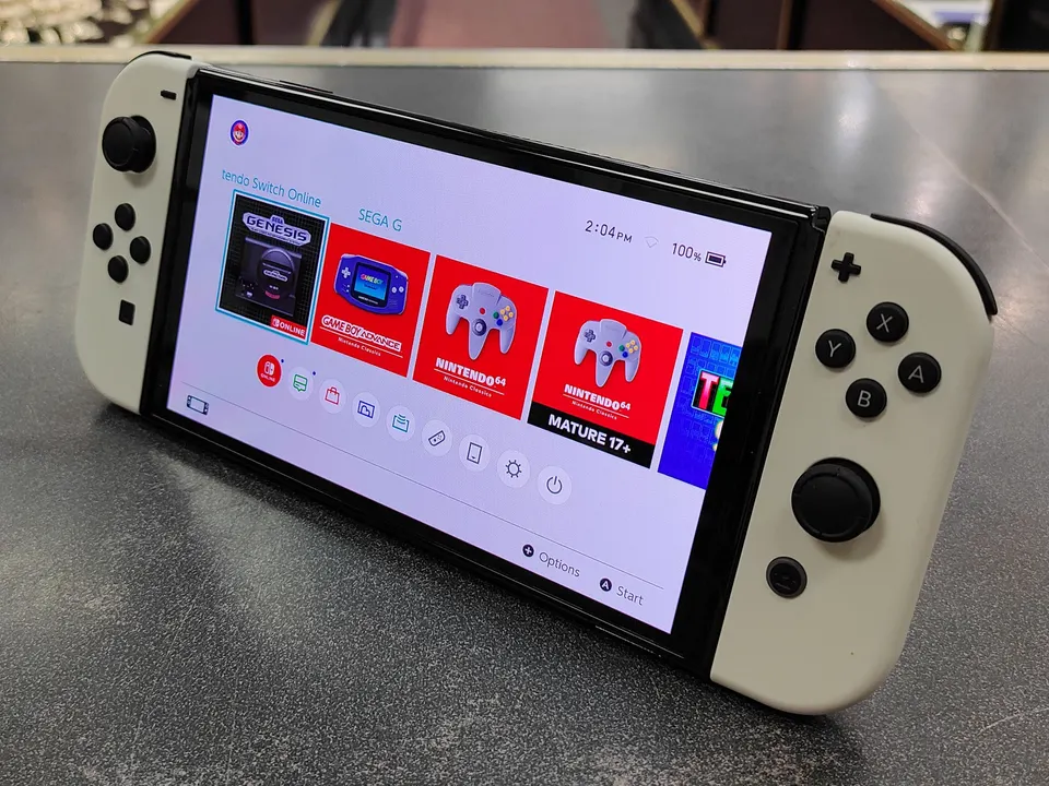 Nintendo Switch OLED White console with dock, Joy-Con controllers, charger, HDMI cable, grip, and wrist straps