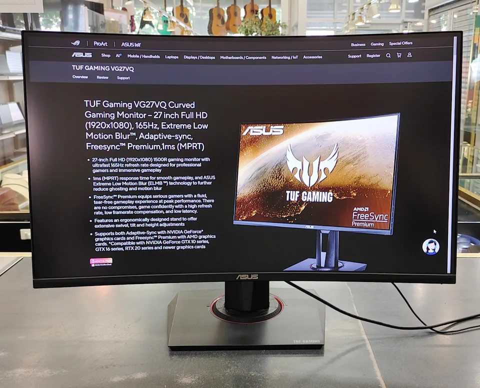 ASUS TUF Gaming VG27VQ 27-inch curved gaming monitor shown powered on with adjustable stand, power adapter, and HDMI cable