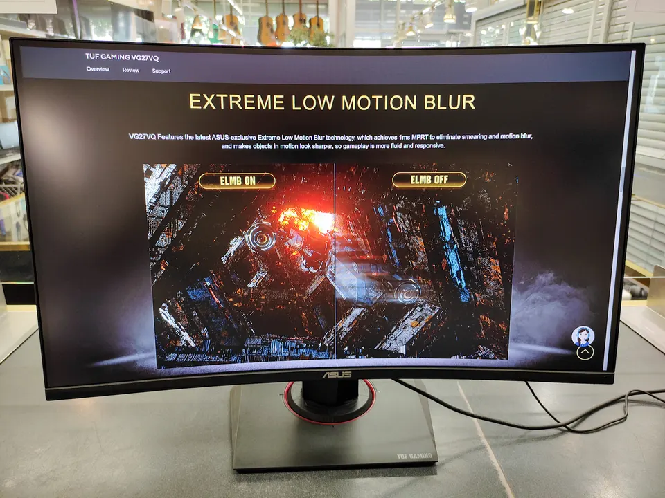 ASUS TUF Gaming VG27VQ 27-inch curved gaming monitor shown powered on with adjustable stand, power adapter, and HDMI cable