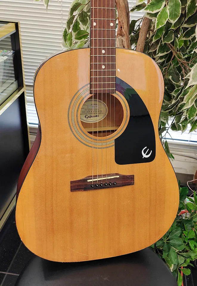 Epiphone AJ-100NA natural finish acoustic guitar showing full body, headstock, bridge, back, sides, tuners, and minor cosmeti