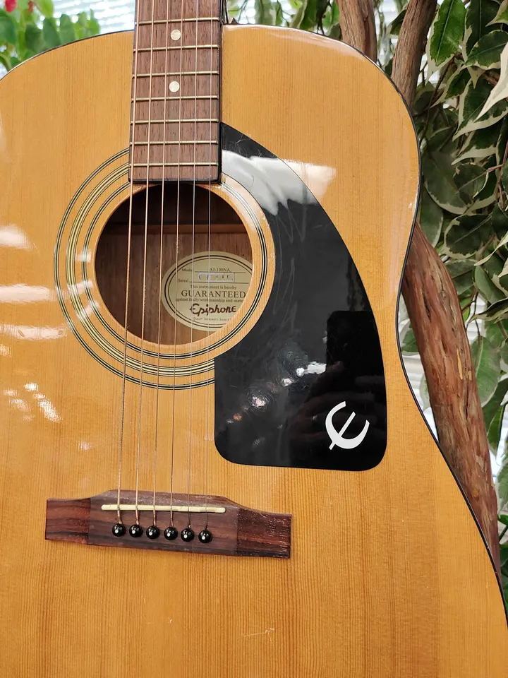 Epiphone AJ-100NA natural finish acoustic guitar showing full body, headstock, bridge, back, sides, tuners, and minor cosmeti