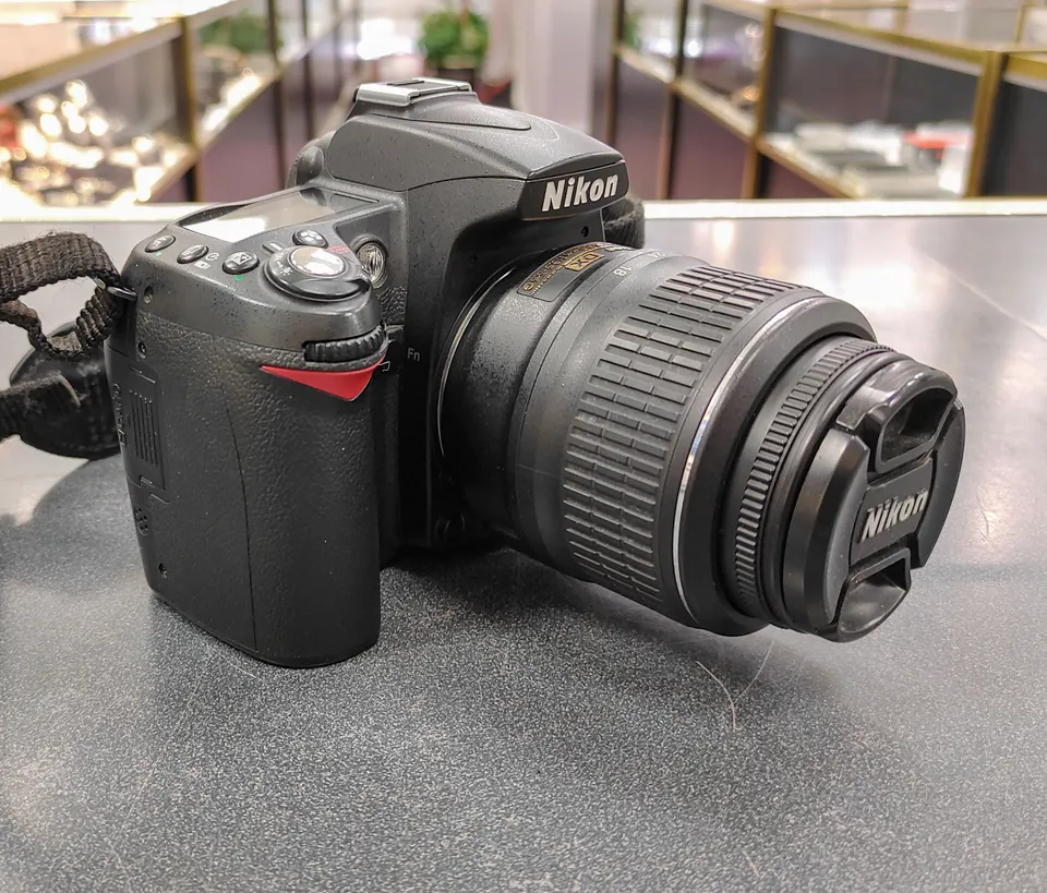 Nikon D90 DSLR camera with 18-55mm VR lens, Nikon battery, charger and neck strap