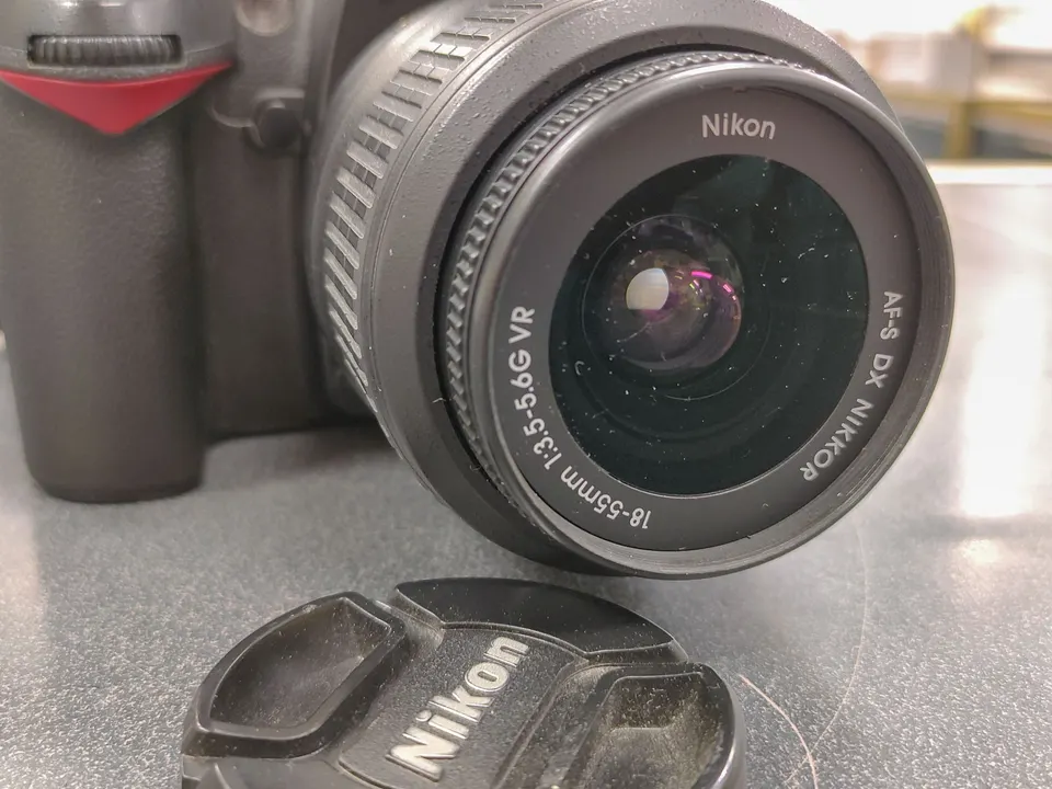 Nikon D90 DSLR camera with 18-55mm VR lens, Nikon battery, charger and neck strap