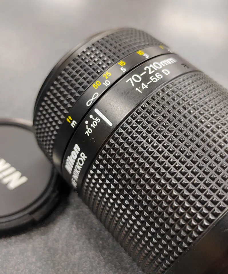 Nikon AF Nikkor 70–210mm f/4–5.6D zoom lens with front and rear caps