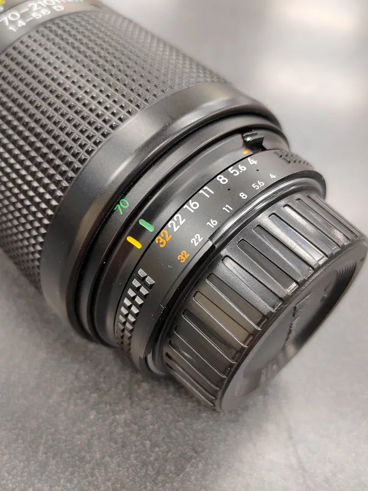 Nikon AF Nikkor 70–210mm f/4–5.6D zoom lens with front and rear caps